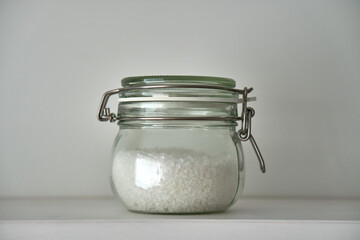  Glass jars with a lid for food on a white shelf. Storage in the kitchen. Containers with bulk products. Transparent container.