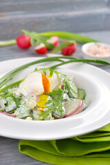 summer salad of cucumbers and radishes with poached egg