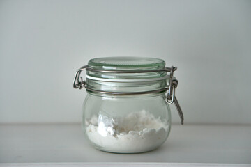  Glass jars with a lid for food on a white shelf. Storage in the kitchen. Containers with bulk products. Transparent container.