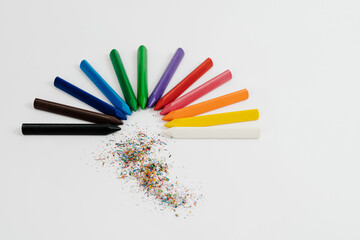 Rainbow of wax crayons with waste