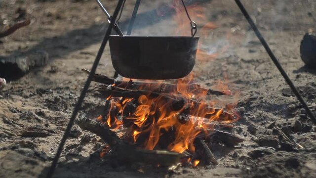 cauldron at the stake. camping in the wood. cooking on the fire. field kitchen. in a pot coming to a boil. a fire built up under a wash pot for scalding water. soup in his bowl.