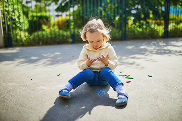 Girl at her dirty hands after drawing with colorful chalks