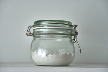  Glass jars with a lid for food on a white shelf. Storage in the kitchen. Containers with bulk products. Transparent container.