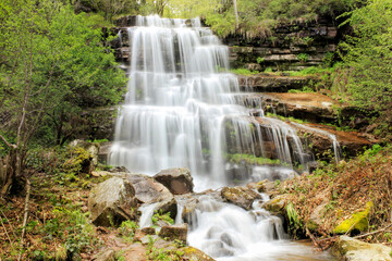 Fototapeta na wymiar Silky water streams and cascades of powerful, sunlit Tupavica waterfall on Old mountain at late spring