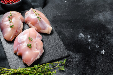 Chicken thigh fillet without skin. Black background. Top view. Copy space
