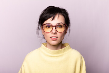 cute woman in a yellow sweater and glasses for vision, gray background