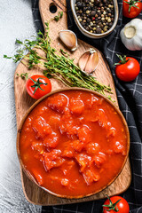 Canned chopped tomatoes, tomato sauce in a bowl. White background. Top view