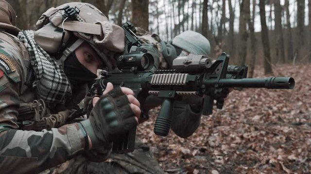 soldier inserts a clip into a rifle in slow motion
