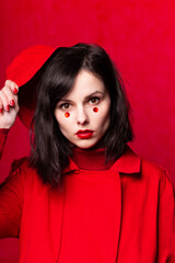 glamorous woman in panama on red background studio, portrait