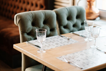 Green armchair in an empty cafe during pandemic. No guests. Served table.