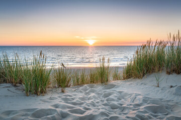 Zachód słońca na plaży z wydmami trawiastymi