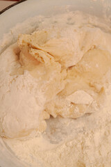 Raw dough mixed in a bowl for making homemade dumplings