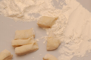 Sliced raw dough into pieces prepared for cooking homemade dumplings