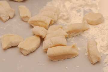 Fototapeta na wymiar Sliced raw dough into pieces prepared for cooking homemade dumplings