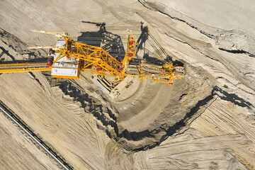 Huge bucket wheel excavator or mobile strip mining machine mining coal in a quarry. Heavy industry...