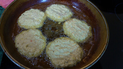 Potato pancakes are fried in a hot pan. Top view. Kitchen concept.