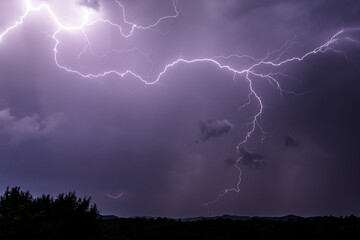 Powerful and dramatic lightning falling onto the ground during heavy thunderstorm in Romania's...