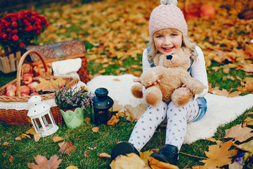 Cute child in a autumn park. Elegant little lady in a cute pink hat
