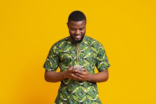 Cheerful african man looking at smartphone screen