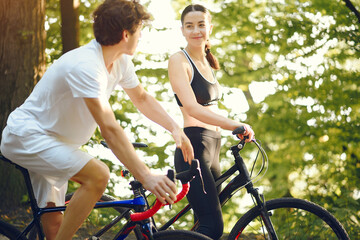 Obraz premium People with a bikes. Couple in a forest. Morning bike ride.