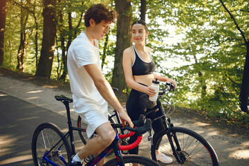 Obraz premium People with a bikes. Couple in a forest. Morning bike ride.
