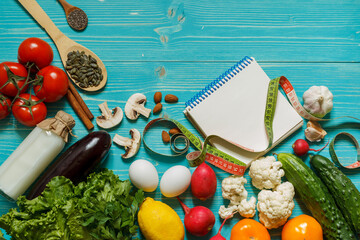 A set of products for an alkaline diet, a Notepad and a centimeter on a wooden aquamarine background with space