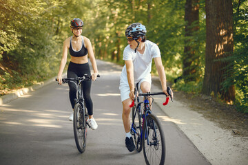Fototapeta premium People with a bikes. Couple in a forest. Morning bike ride.