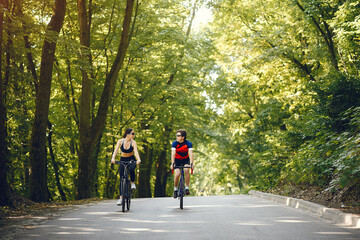 Obraz premium People with a bikes. Couple in a forest. Morning bike ride.