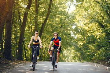 Obraz premium People with a bikes. Couple in a forest. Morning bike ride.