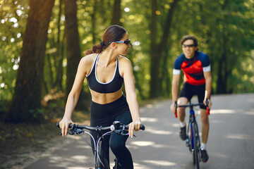 Naklejka premium People with a bikes. Couple in a forest. Morning bike ride.