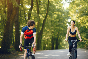 Obraz premium People with a bikes. Couple in a forest. Morning bike ride.