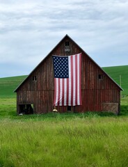 Rustic old barn with American Flag hanging on the side © Lori