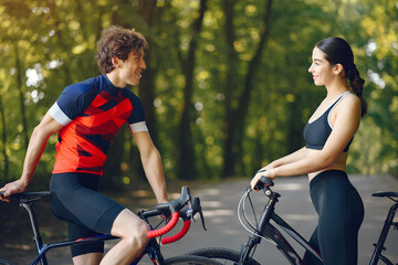 Obraz premium People with a bikes. Couple in a forest. Morning bike ride.