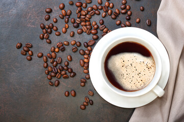 Obraz na płótnie Canvas Coffee cup and coffee beans on dark table.