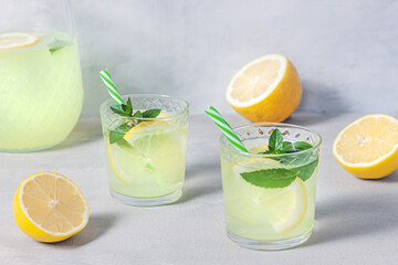 Lemon lemonade with herb on grey background.