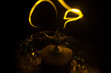 Lamp of wishes concept. Antique Aladdin arabian nights genie style oil lamp with soft light white...