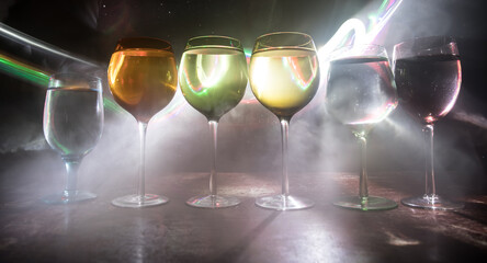 Goblet of white wine on wooden table on wooden wall background