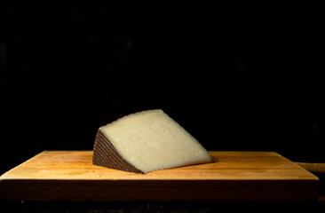left manchego on wood in black background
