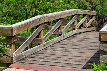Close up abstract partial view of a rustic wooden bridge over a river in a woodland setting