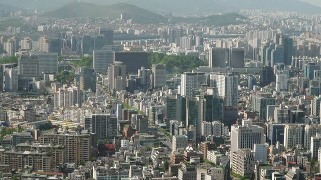 Aerial view of Seoul downtown city skyline and busy cars traffic on city streets of Seocho District, South Korea, day time, following street car motion