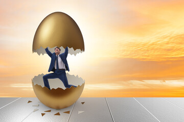 Businessman breaking out of golden egg