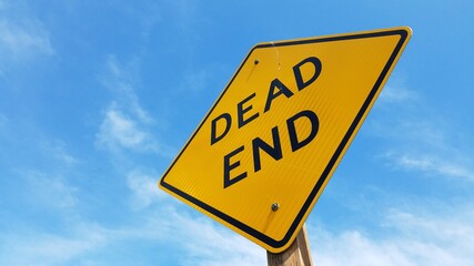Dead End sign in closeup with clear blue sky background