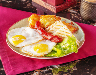 Fried eggs, grilled sausage, grilled bread, lettuce, potato pancakes. Breakfast is on the table.
