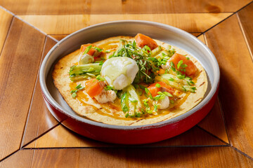 Egg omelet, arugula, cherry tomatoes, poached egg. Breakfast is on the table.