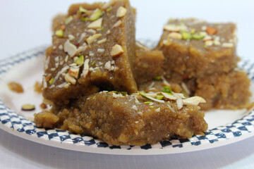 Indian Traditional sweet Lapsior shira or Halwa made from broken wheat,jaggery and desi gheeand garnished with nuts.selective focus.