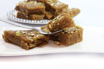 Indian Traditional sweet Lapsior shira or Halwa made from broken wheat,jaggery and desi gheeand garnished with nuts.selective focus.