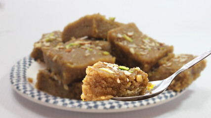 Indian Traditional sweet Lapsior shira or Halwa made from broken wheat,jaggery and desi gheeand garnished with nuts.selective focus.