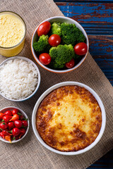 Escondidinho. Typical Brazilian food. Made from potatoes and chicken. .Accompanied by rice and salad