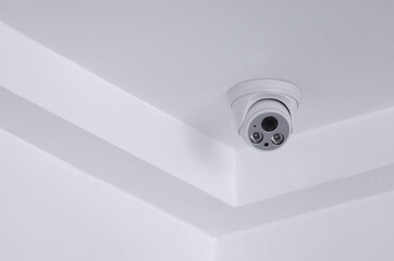 CCTV security camera on white ceiling, operating inside the building with copy space. concept of safety control, crime protect.