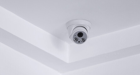 CCTV security camera on white ceiling, operating inside the building with copy space. concept of safety control, crime protect.